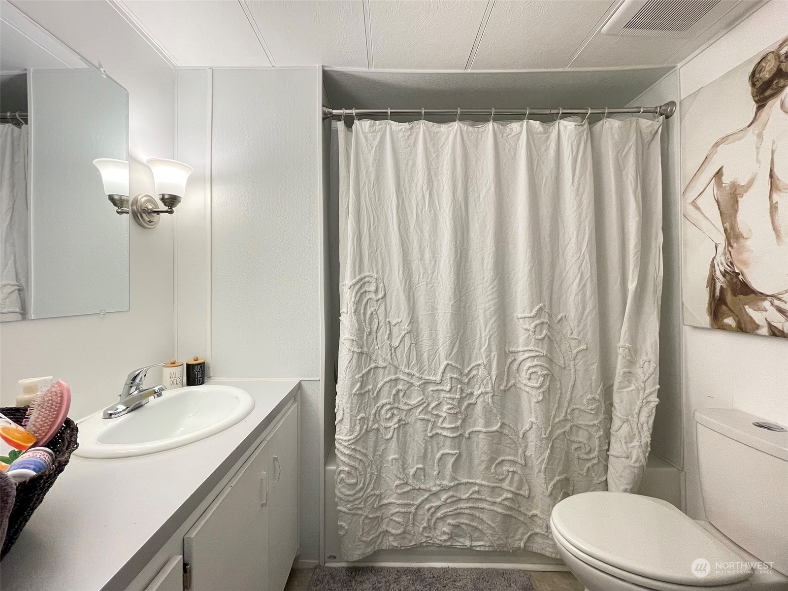 277 House Road Sequim, WA 98382 - Photo 29 of 40 a bathroom with a sink a toilet and shower curtain