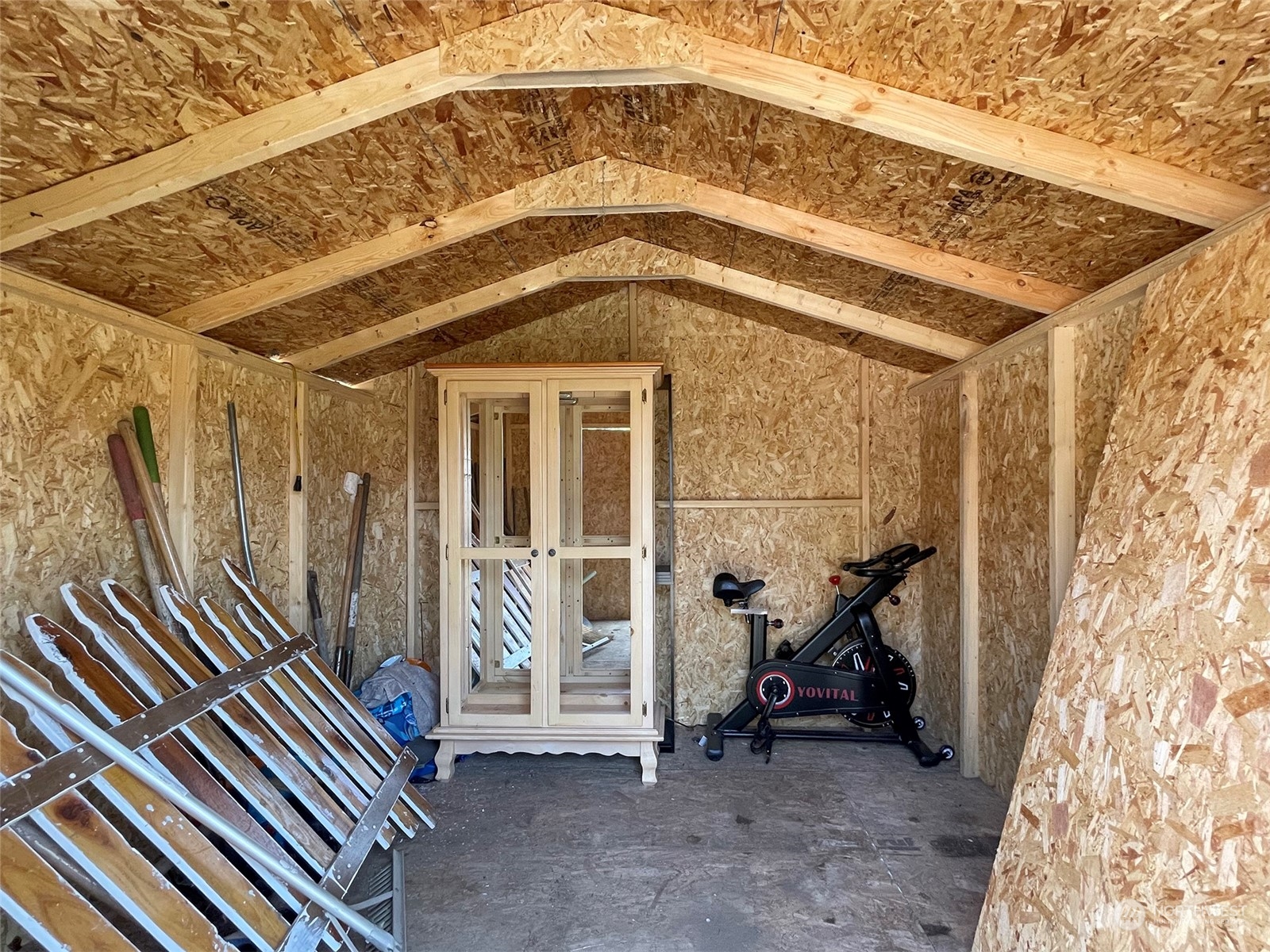 277 House Road Sequim, WA 98382 - Photo 40 of 40 a view of a hallway with a bike and wooden roof