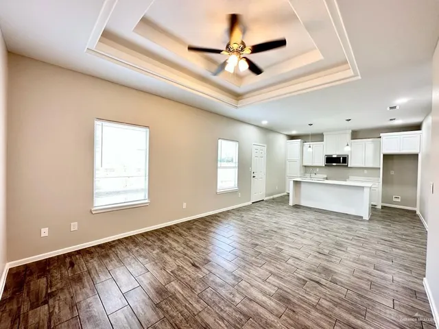 a view of a kitchen with wooden floor and a ceiling fan