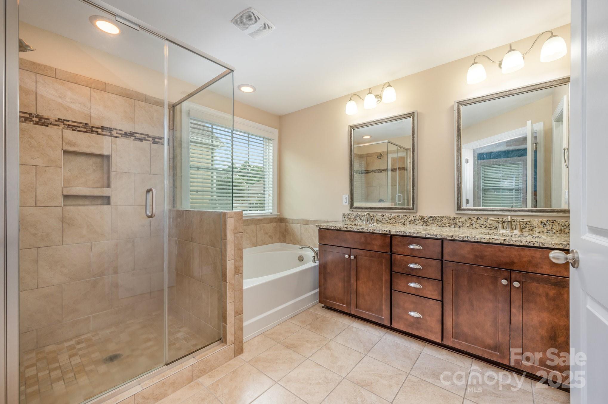 819 Coralbell Way Tega Cay, SC 29708 - Photo 16 of 33 a spacious bathroom with a tub sink shower and mirror