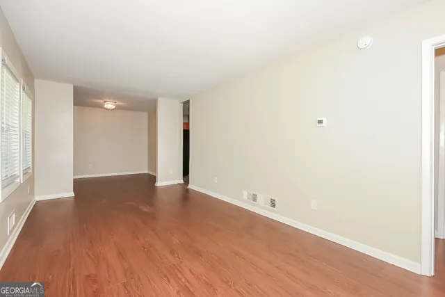 a view of an empty room with wooden floor
