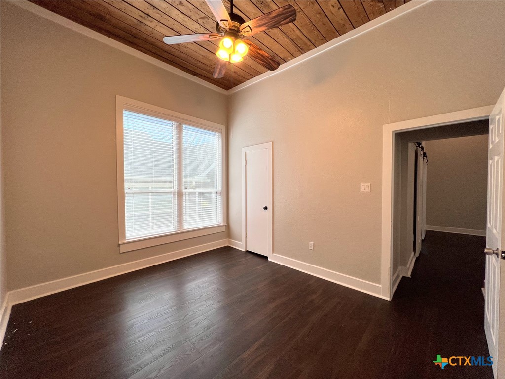 111 North 5th Street Temple, TX 76501 - Photo 14 of 19 an empty room with wooden floor chandelier fan and windows