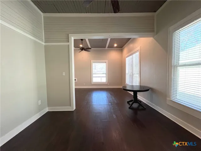 a view of a hallway with wooden floor and a chandelier