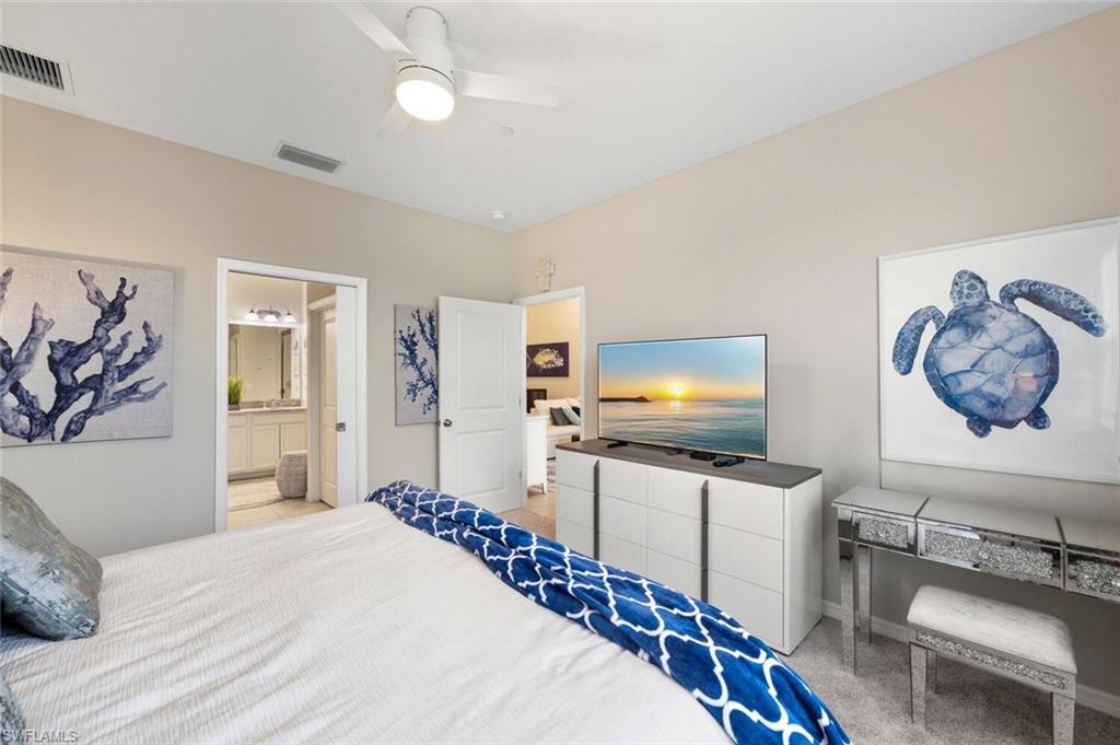 9365 Pocida Court, Unit 202 Naples, FL 34119 - Photo 20 of 40 a bedroom with furniture and a flat screen tv