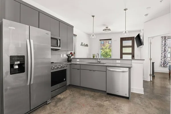 a kitchen with stainless steel appliances granite countertop a refrigerator a sink and a stove