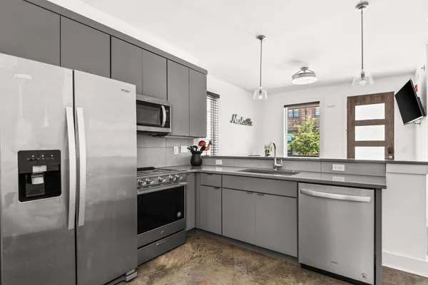 a kitchen with stainless steel appliances a refrigerator sink and white cabinets