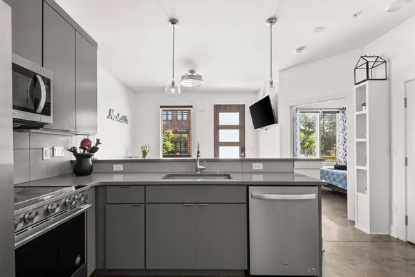 a kitchen with kitchen island granite countertop a sink appliances cabinets and a counter top space