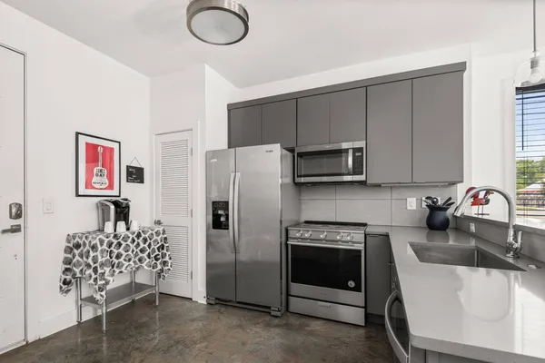 a kitchen with stainless steel appliances granite countertop a refrigerator sink and stove