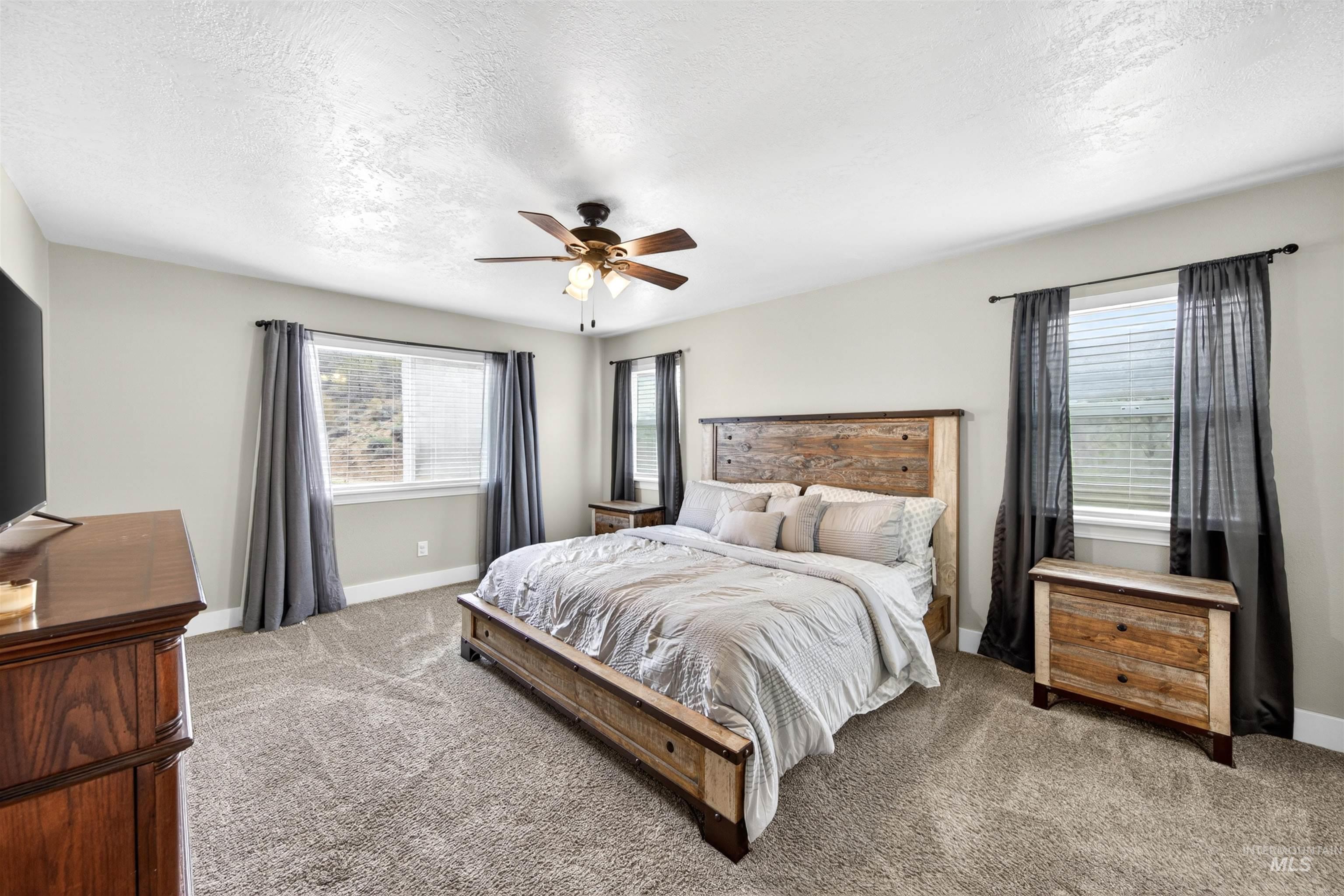 4 Round Up Circle Boise, ID 83716 - Photo 22 of 47 Carpeted bedroom featuring light gray walls, white baseboards, and a ceiling fan with integrated lighting