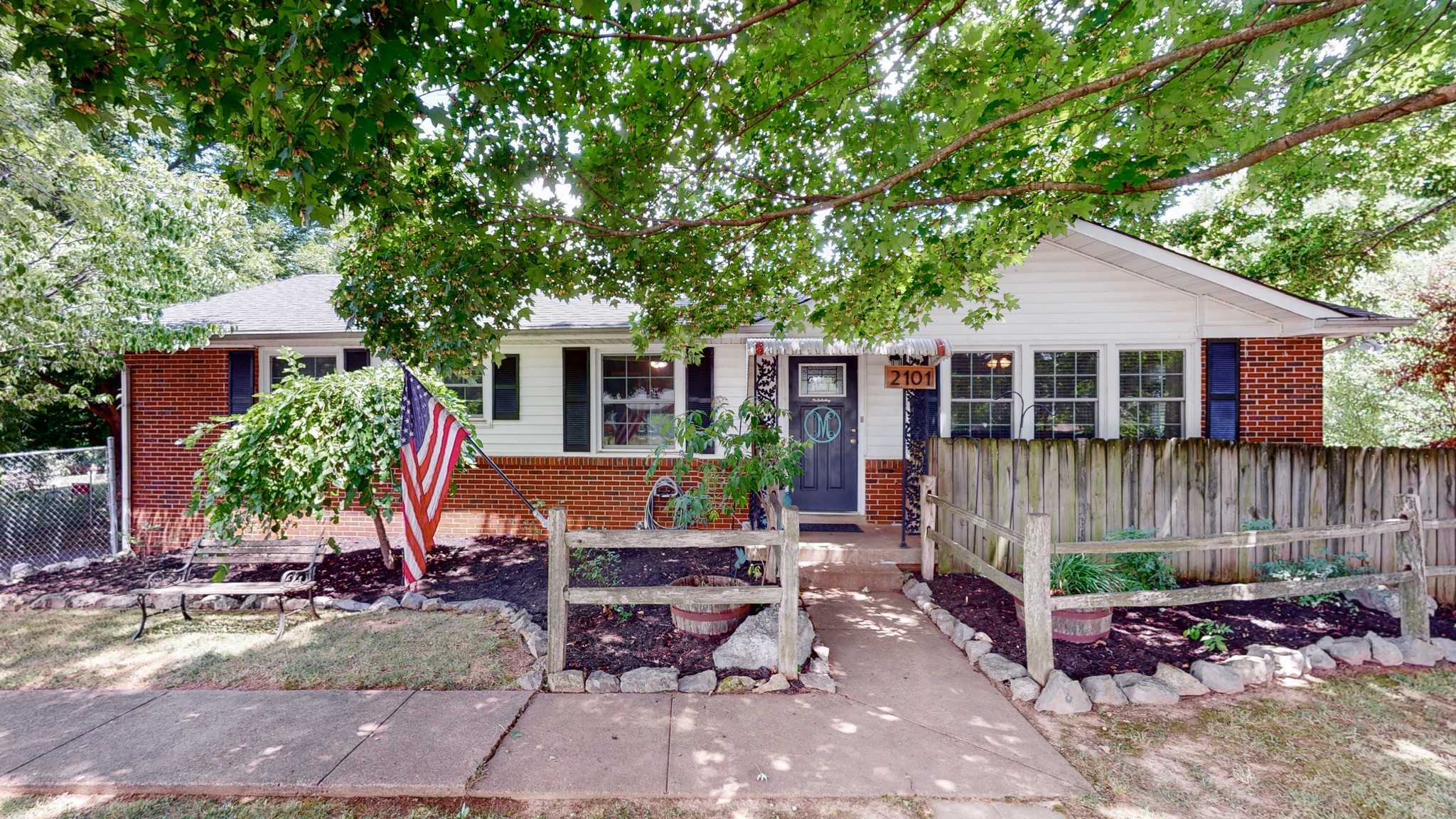 a view of a house with backyard sitting area and a tree