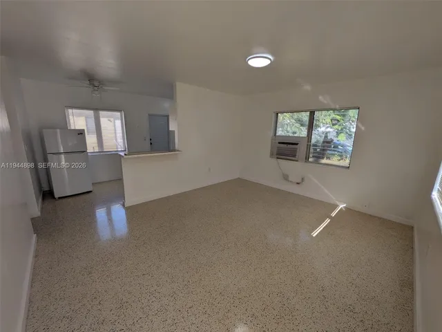 en empty room with windows and cabinet