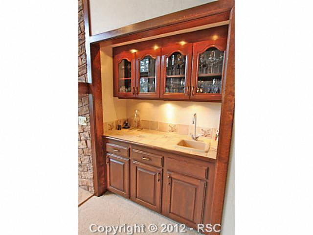 13010 Bridle Bit Road Colorado Springs, CO 80908 - Photo 10 of 25 Wet bar is located in the living room area and features ample cabinetry, counterspace and lighting.