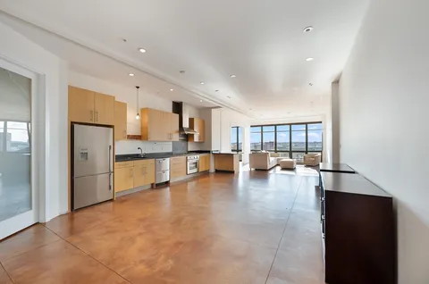 a large kitchen with a large window and stainless steel appliances