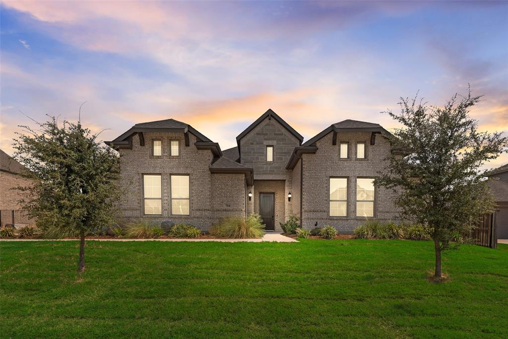 View of front of property with a front yard and brick siding
