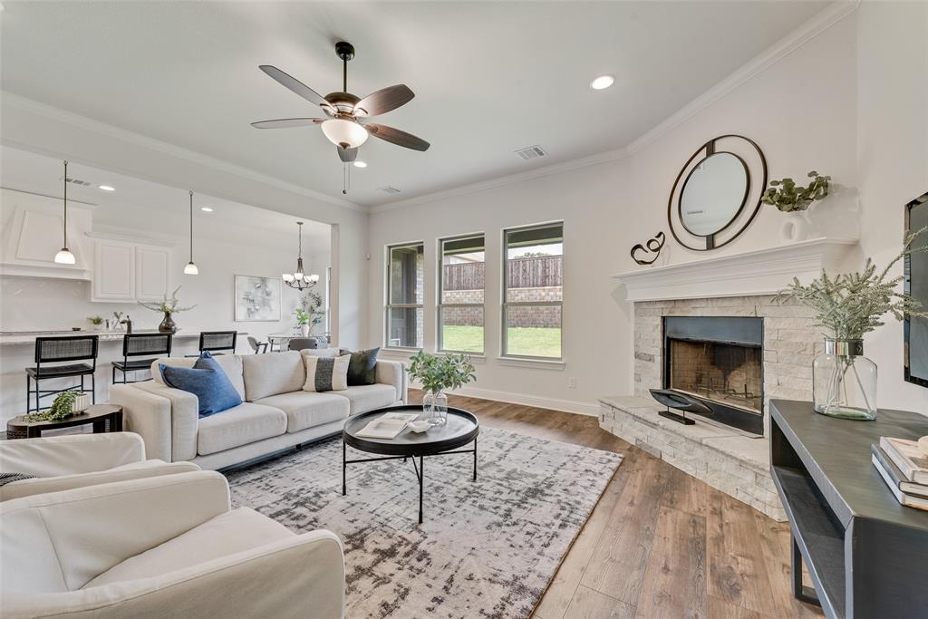 704 Toby Trail Mansfield, TX 76063 - Photo 14 of 40 Living room with crown molding, light wood-type flooring, a chandelier, recessed lighting, and a fireplace