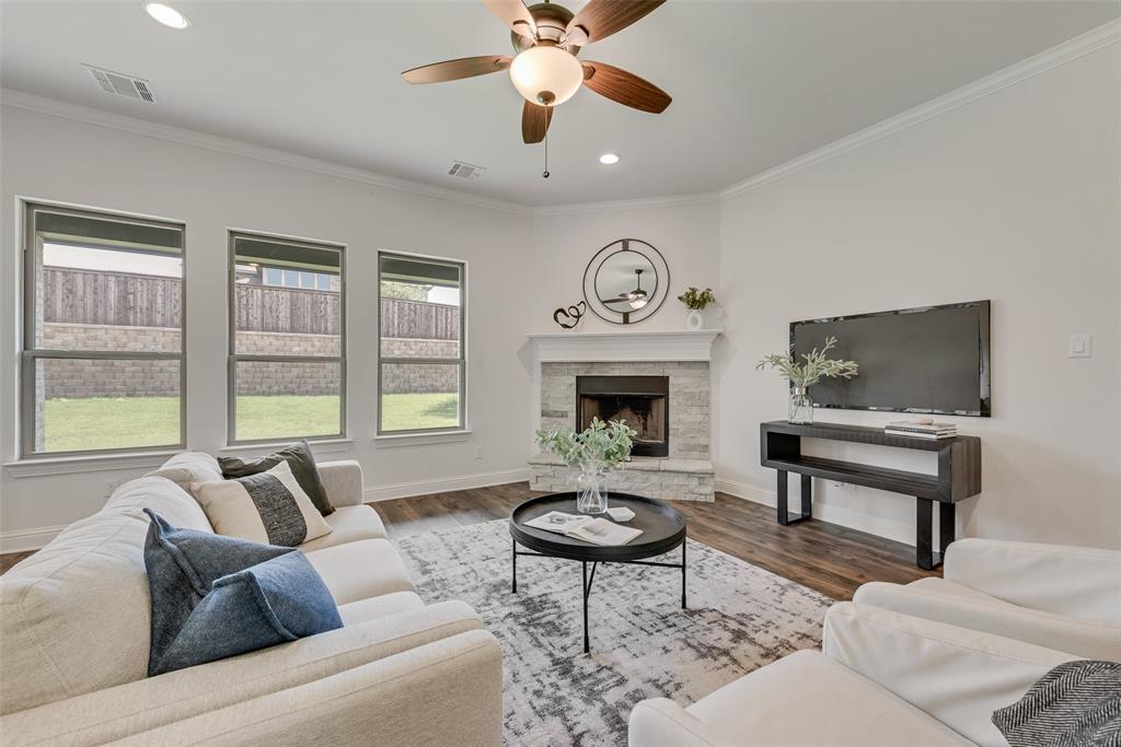 704 Toby Trail Mansfield, TX 76063 - Photo 15 of 40 Living area featuring crown molding, wood finished floors, a fireplace, a ceiling fan, and recessed lighting
