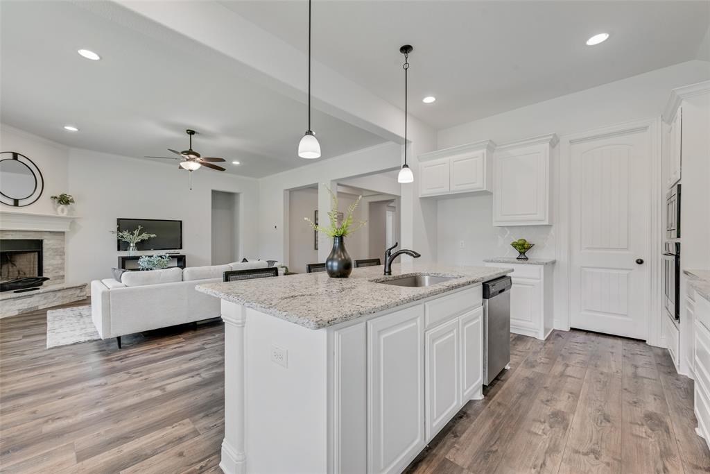 704 Toby Trail Mansfield, TX 76063 - Photo 22 of 40 Kitchen featuring white cabinetry, light stone countertops, pendant lighting, light wood-style flooring, and recessed lighting