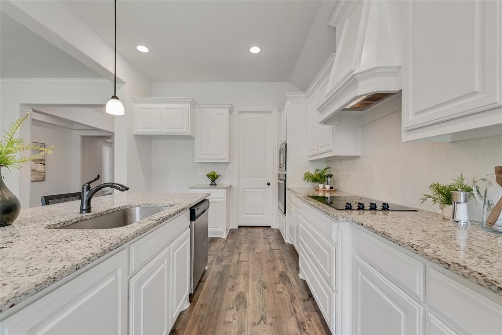 704 Toby Trail Mansfield, TX 76063 - Photo 23 of 40 Kitchen featuring backsplash, dark wood finished floors, white cabinets, light stone countertops, and recessed lighting