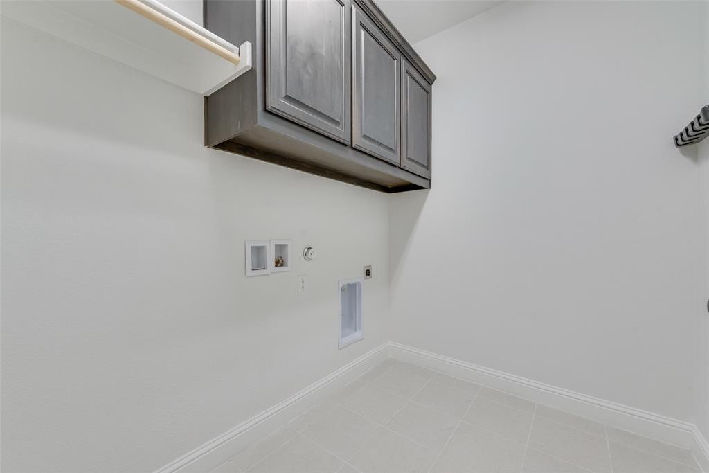 704 Toby Trail Mansfield, TX 76063 - Photo 36 of 40 Laundry room featuring hookup for a gas dryer, cabinet space, hookup for a washing machine, light tile patterned flooring, and hookup for an electric dryer