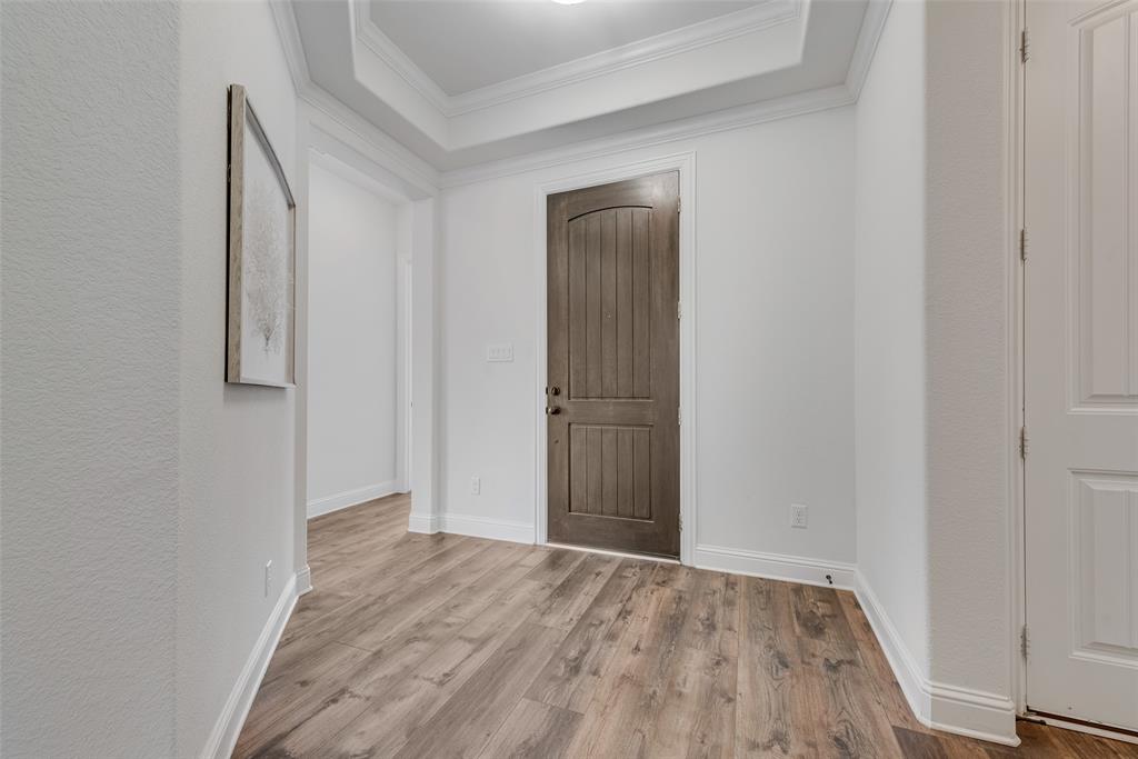 704 Toby Trail Mansfield, TX 76063 - Photo 10 of 40 Entryway with wood finished floors, crown molding, and a tray ceiling