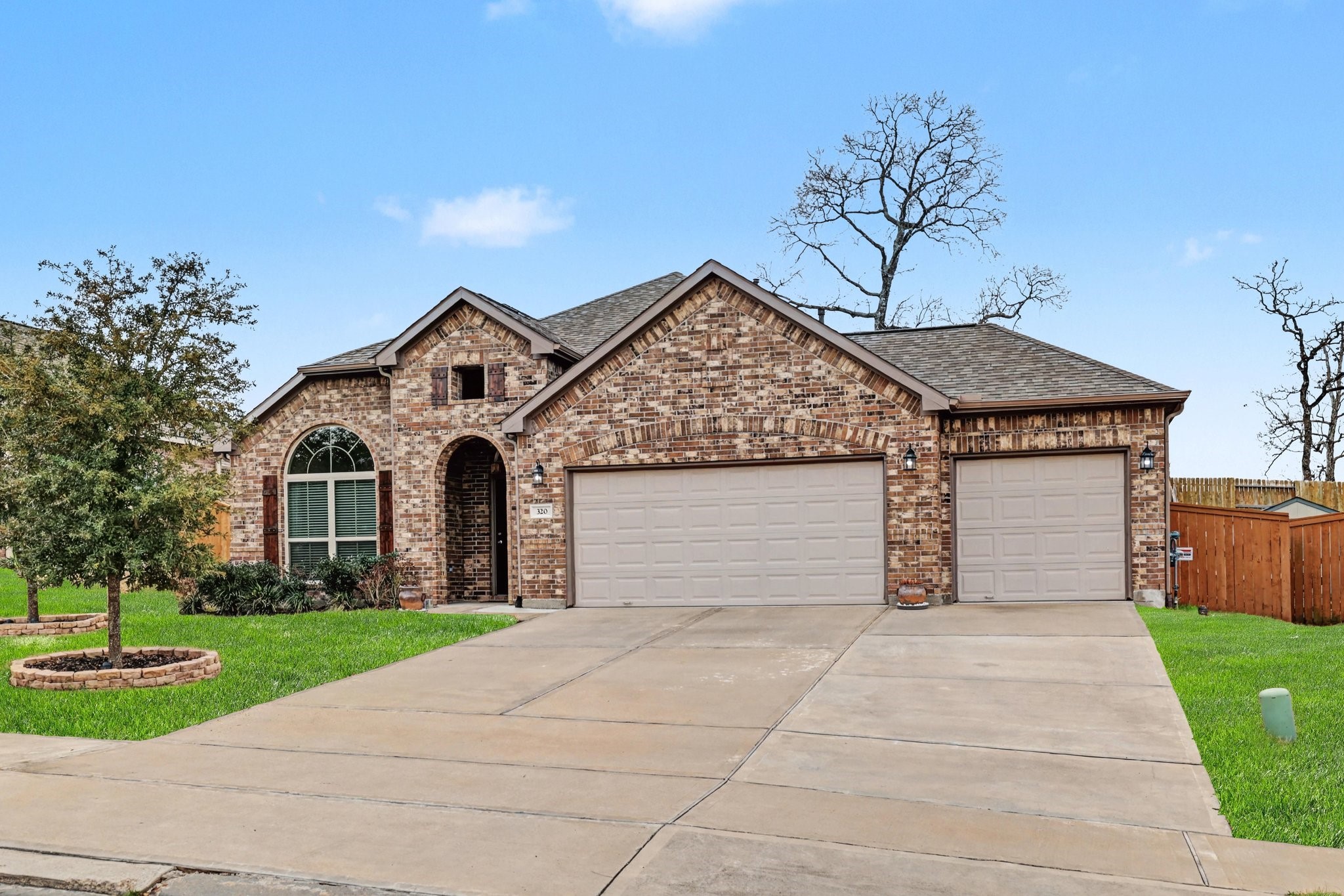 320 Red Maple Lane Conroe, TX 77304 - Photo 2 of 24 Featuring a 3-car garage with pull-through door and expanded driveway.