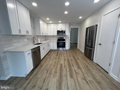a large kitchen with a large counter top appliances and cabinets