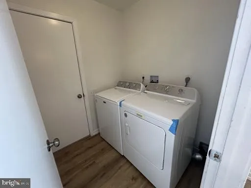 a view of an empty room with wooden floor and a fireplace
