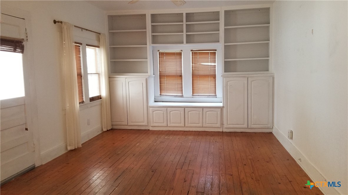 1123 West Coll Street New Braunfels, TX 78130 - Photo 17 of 24 an empty room with wooden floor and windows