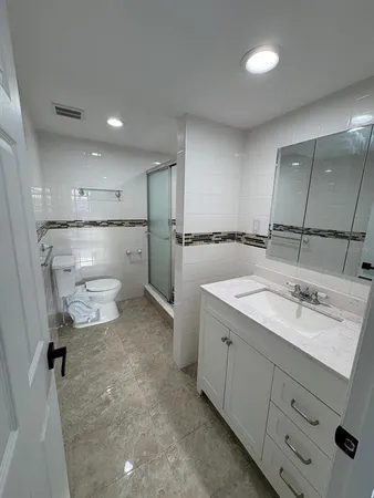 a bathroom with a sink toilet and shower
