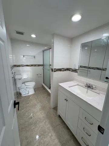 a bathroom with a sink toilet and shower