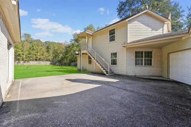 a view of a house with backyard and trees