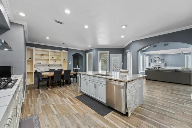a kitchen with stainless steel appliances granite countertop a stove and a wooden floors