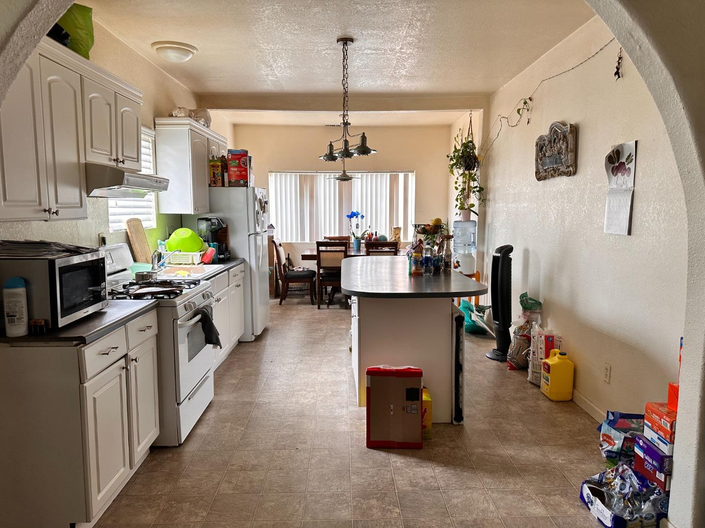 323 Maple Street Salinas, CA 93901 - Photo 2 of 15 a kitchen with stainless steel appliances kitchen island granite countertop a stove and a sink