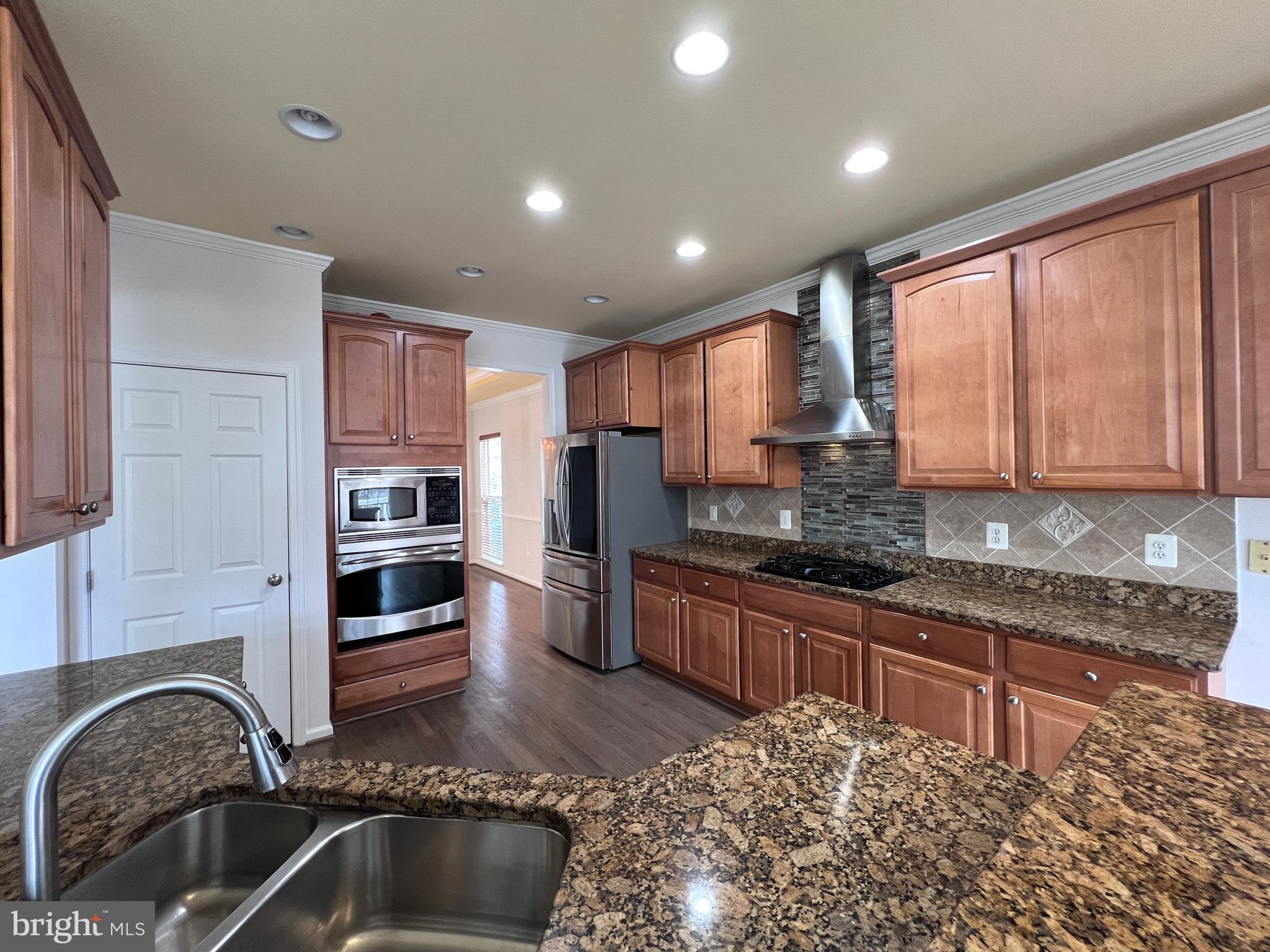 3925 Beeker Mill Place Chantilly, VA 20151 - Photo 6 of 40 a kitchen with stainless steel appliances granite countertop a stove a sink and a refrigerator