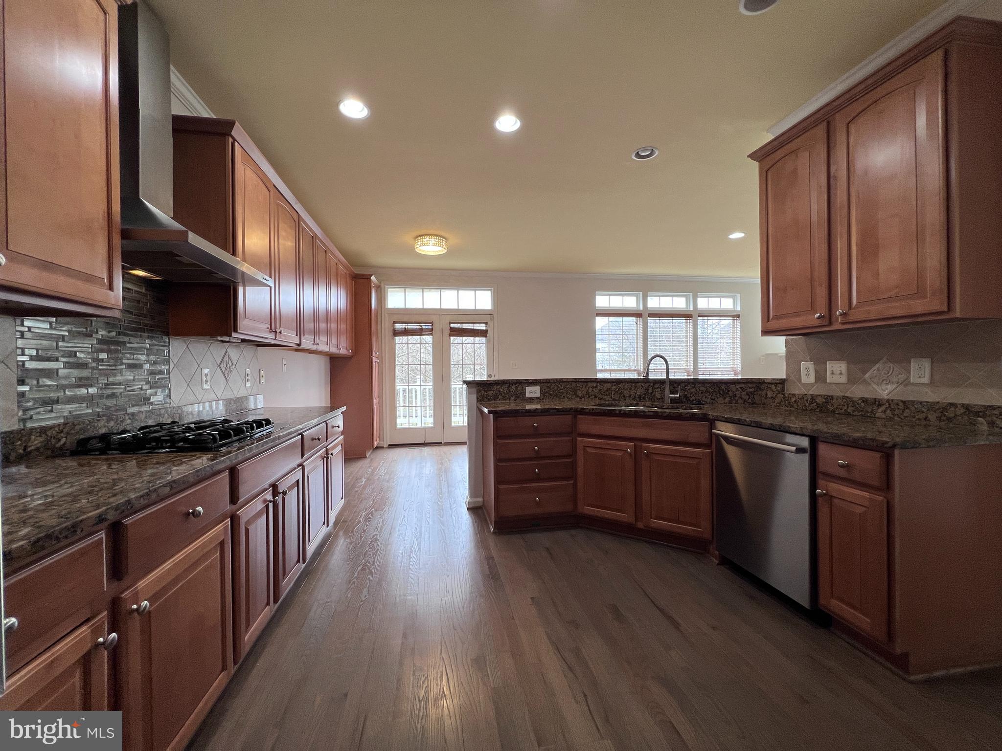 3925 Beeker Mill Place Chantilly, VA 20151 - Photo 9 of 40 a kitchen with stainless steel appliances granite countertop wooden cabinets a stove top oven a sink and dishwasher