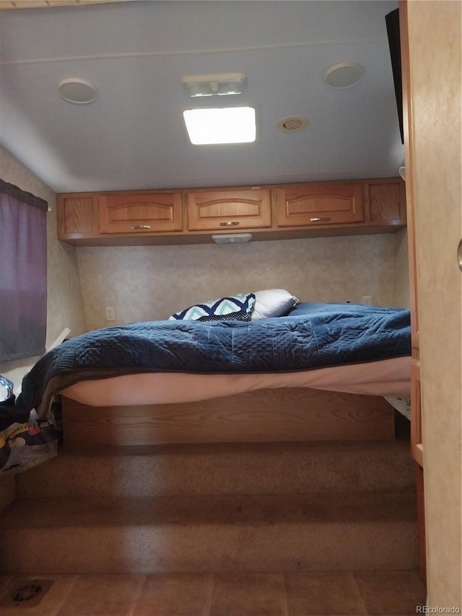 6642 Co Road Wiggins, CO 80654 - Photo 15 of 17 a bed sitting in a room next to a window