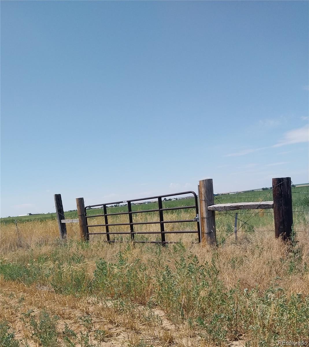 6642 Co Road Wiggins, CO 80654 - Photo 8 of 17 a view of outdoor space with deck and yard