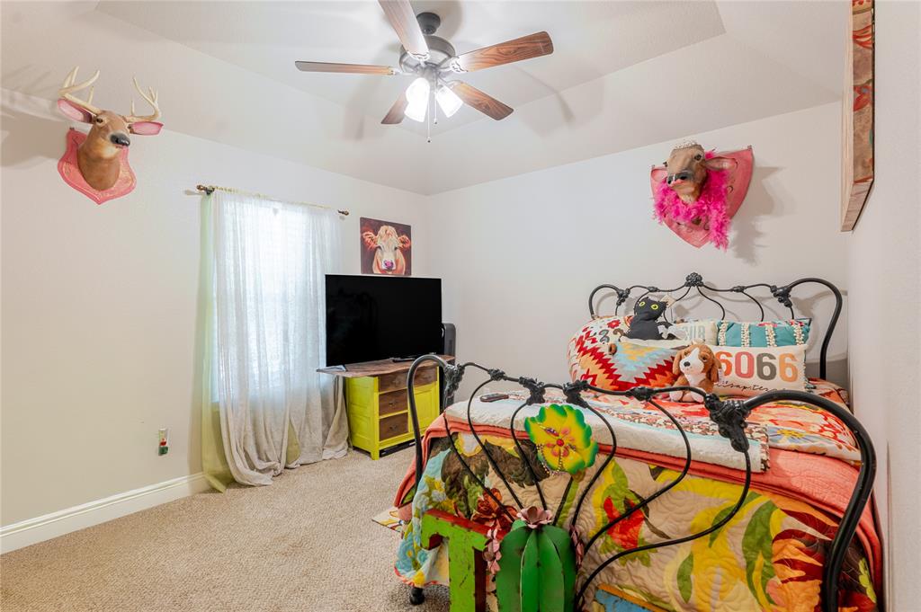 470 Wilson Bend Road Millsap, TX 76066 - Photo 24 of 39 a bedroom with a bed a flat screen tv and a chandelier