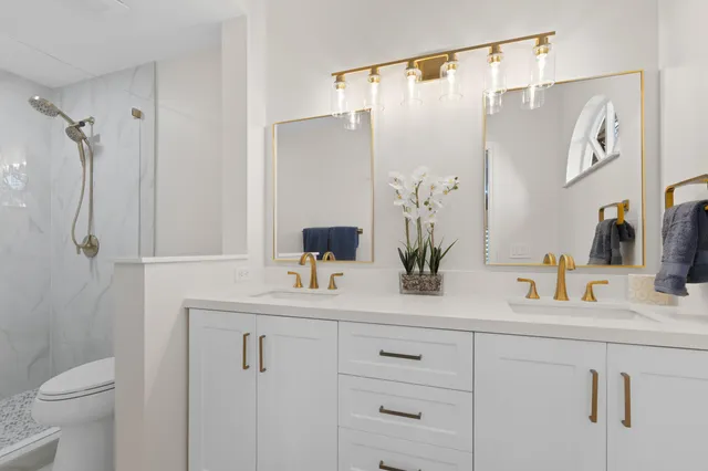 a bathroom with a shower sink vanity and toilet