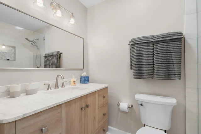 a bathroom with a sink a toilet and a mirror