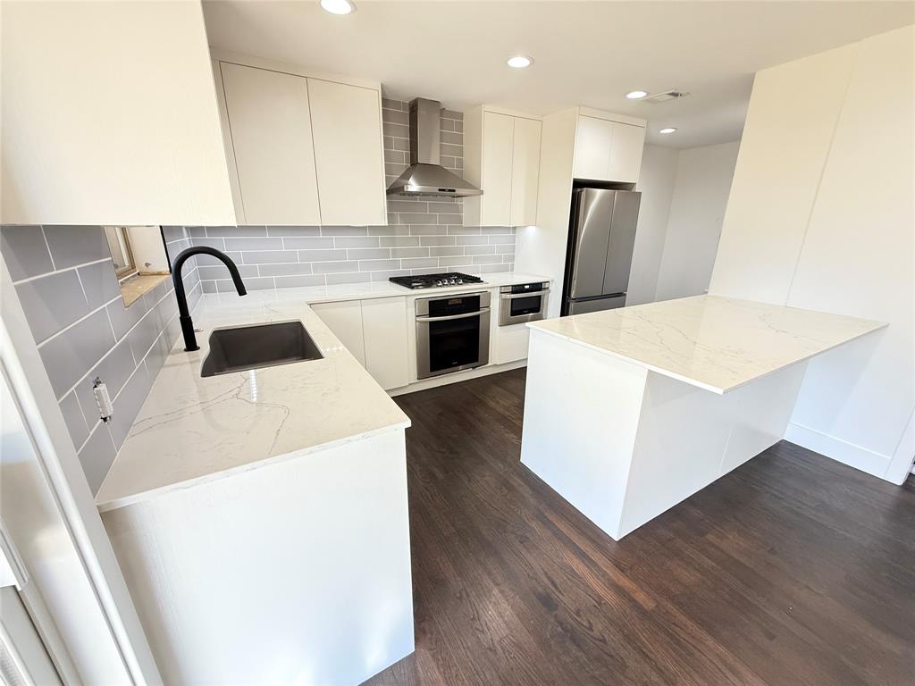 425 Chesier Road Lancaster, TX 75146 - Photo 4 of 15 a kitchen with kitchen island wooden cabinets and white appliances
