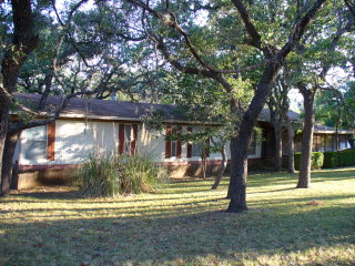a view of a wooden house with a yard