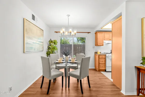 a dining room with furniture a chandelier and wooden floor