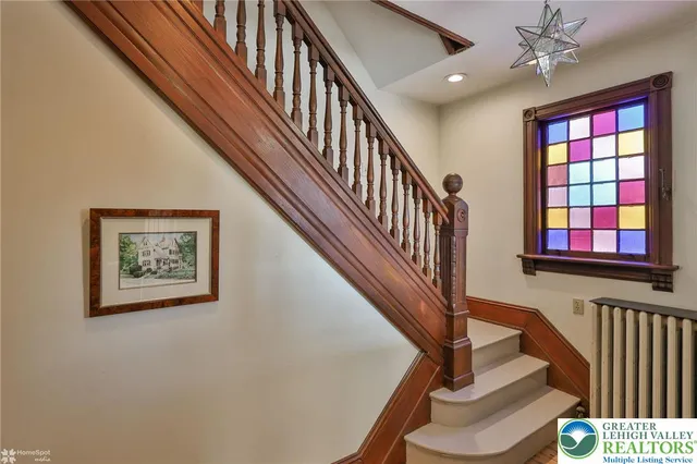 a view of a hallway with wooden floor and windows