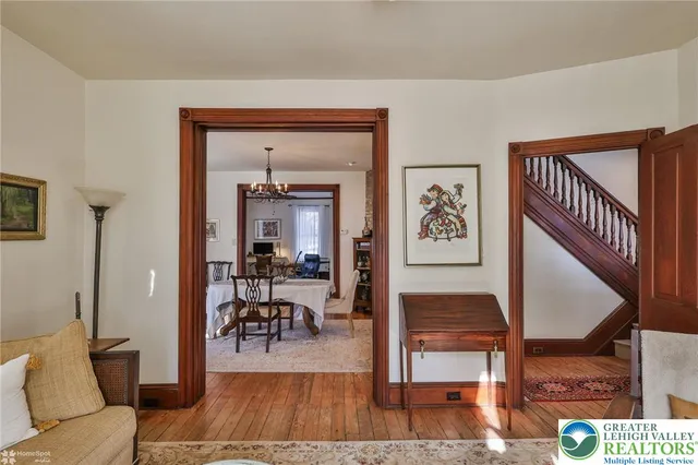 a kitchen with stainless steel appliances kitchen island granite countertop a stove a refrigerator a sink a dining table and chairs with wooden floor