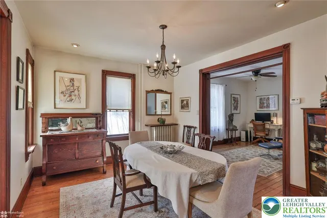 a kitchen with stainless steel appliances granite countertop a stove a sink dishwasher a dining table and chairs with wooden floor