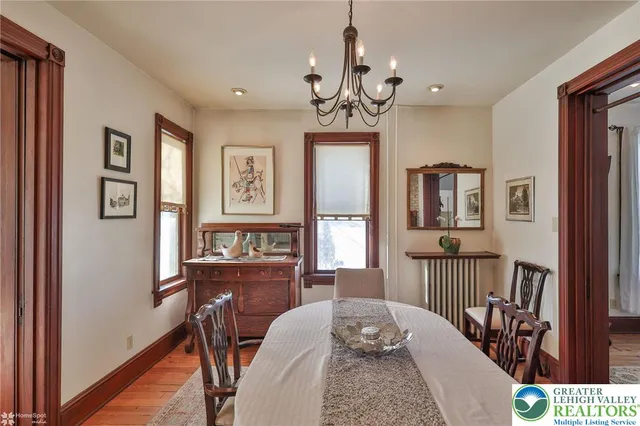 a view of a dining room with furniture a chandelier and large windows