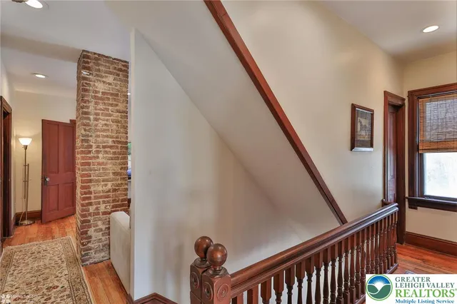 a living room with furniture a clock and a flat screen tv