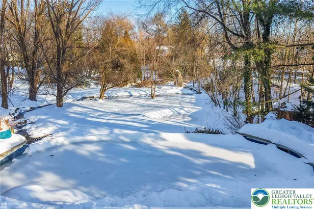 a view of roof deck with dining table and chairs under an umbrella