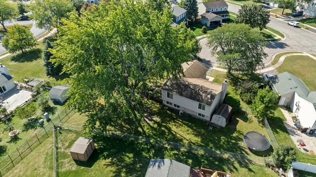 an aerial view of a house with a yard and large trees